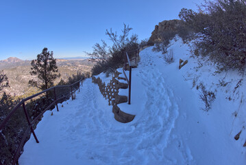 The Thumb Butte Recreation Area day use hiking trail in the Prescott National Forest just west of Prescott Arizona, covered in winter snow and ice.
