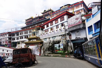 Iconic Darjeeling Himalayan Railway toy train passes famous Dali Monastery in Darjeeling, West...