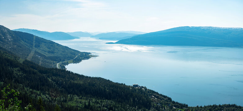 Panorama over Ranfjorden going west from Hauknestinden, 800 m altitude. Peak of Hauknes, Mo i Rana. Mountains dramatically going down into the fjord water below. Clear skies during Norwegian summer.	