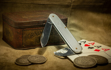 vintage foldable knife with old coins and playing cards