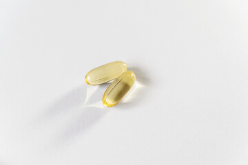 Close up yellow capsules on the white background. Omega 3 oil in capsules. Medical, vitamins, health background