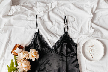gentle black lace nightdress on the bed. Women tender lingerie, underwear. Top view, close up. Flat lay, beauty blog or social media minimal concept. Present for Valentines, Women’ and white lace