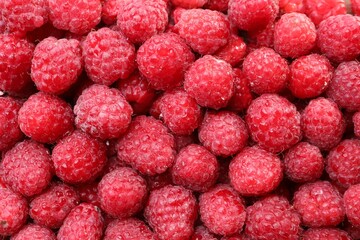 Heap of tasty ripe raspberries as background, top view