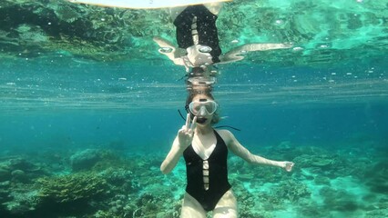 Scuba diver, peace sign and woman swimming in ocean for adventure, holiday and vacation in Mauritius. Snorkeling, travel and female person in tropical water with hand gesture to explore on island