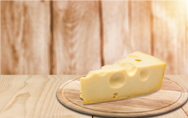 Piece of tasty fresh cheese triangle on board