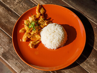 Delicious Thai chicken panang curry and steamed rice on wood background. Thai food top view
