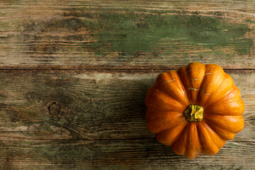 Beautiful orange pumpkin on a wooden background. Autumn concert. Food background with copy space. Top view.