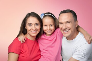 Young parents with child posing together on background