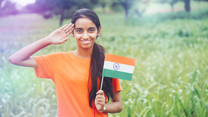 Young girl saluting wearing green t-shirt on the occasion of Indian Independence day celebration