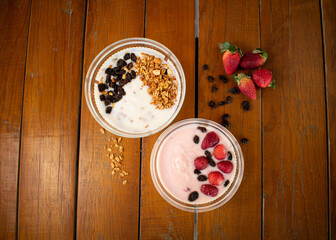 Toma amplia de portada de yogurt con cereales y frutos secos como pasas arandanos y fresas delicioso desayuno en toma cenital 