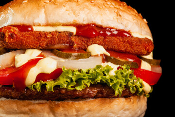 Burger with meat and fried yellow cheese with onions tomatoes cucumber lettuce and sauces. Abstract fast food photo.