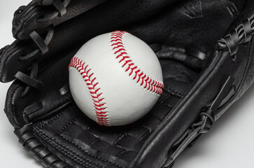 Closeup of a white baseball ball inside baseball glove