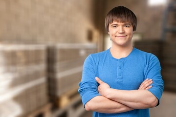 Young male folding arms in modern factory