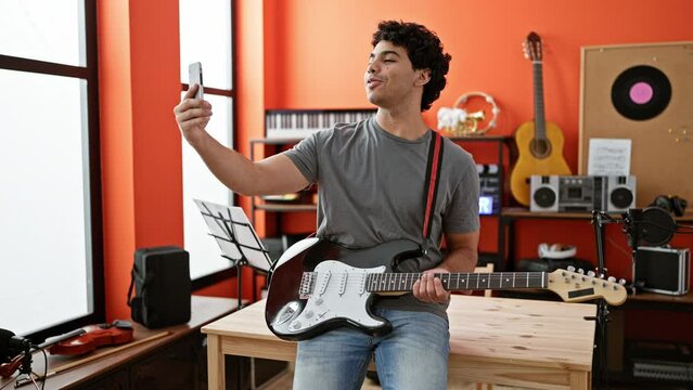 Young latin man musician having video call smiling at music studio