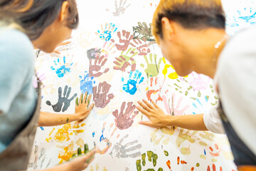 Group of Asian generation z people learning acrylic painting art by hand on canvas workshop at art studio. Young artist university student enjoy and fun creating colorful abstract modern art in class.