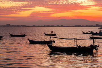 Colourful sunset sky over the sea with silhouette boat on the horizon. Tranquility scene. Abstract landscape background. Rural scene.