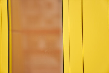 Abstract architecture in yellow with an orange insert. Close-up of the facade of the building. A fragment of a wall with space to copy. High quality photo