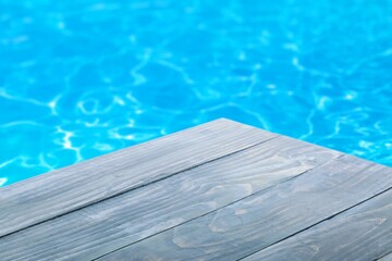 Empty table on swimming pool background in tropical resort