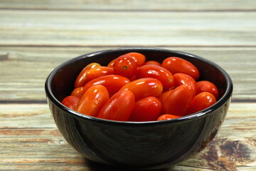 Pile of fresh and organic cherry tomato in the small bowl. Famous tropical vegetable in Asia market.