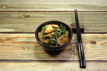 Traditional fried and stirred rice noodle with chicken egg, Chinese kale and pork seasoning with special sauce serving in the small bowl. Famous street food in Chinese restaurant.
