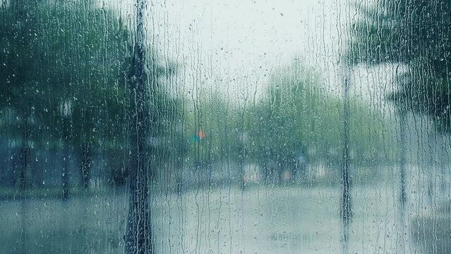 Rain droplets on the window and colorful traffic bokeh light.