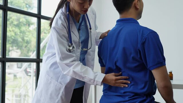 A physiotherapist or medical professional doing physiotherapy on the back scapula and back injury of male athlete patient stretching and exercise cause pain rehabilitation therapy, health insurance.	