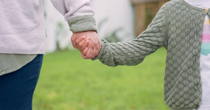 Mother, child or family holding hands outdoor in a backyard for love, care and trust. Closeup of a woman and girl kid together for quality time, security and guidance or support for development