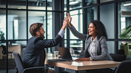 Businesswoman giving a high five to male colleague in meeting. Business professionals high five during a meeting in boardroom.