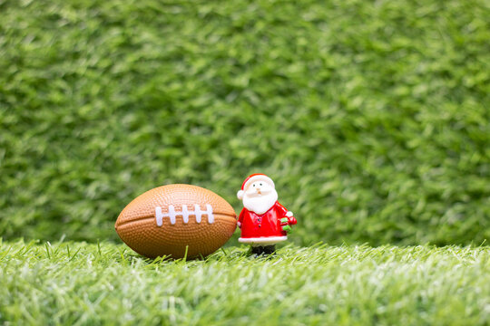 Football for Christmas with Santa Claus on green grass
