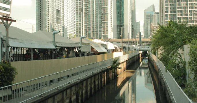 Jodd Fairs Night Market with Canal Alongside with City Buildings in the Background.