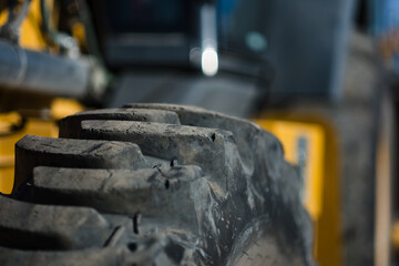 Heavy equipment is lined up at a construction. The machinery has large, well-worn tires with deep treads.