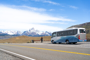 Dos mujeres se están tomando fotografías en la carretera con El Chalten y el Monte Fitz Roy de...