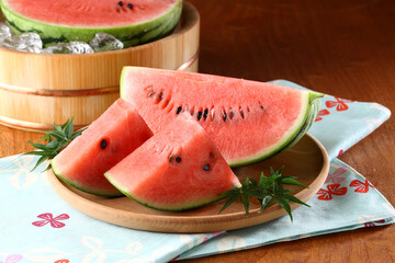 桶で冷やしているスイカとカットしたスイカ