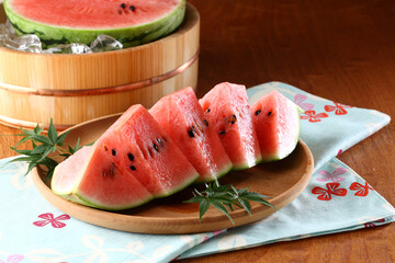 桶で冷やしているスイカとカットしたスイカ