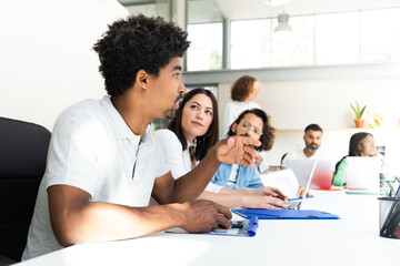 Young african american man talking to coworkers about business in conference room table. Copy space.