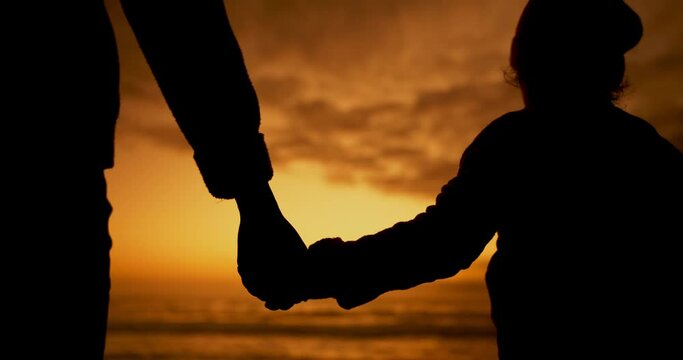 Silhouette, father and child holding hands at beach sunset for care, trust and support. Dad, kid and back at ocean together for love, bonding and travel on holiday, family vacation and summer at sea