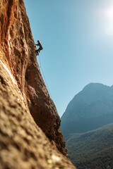 Girl climbs on the rock, rock climbing in Turkey, the sports girl is engaged in rock climbing. © zhukovvvlad