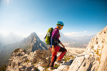 hiking in the mountains. a girl with a backpack walks along a mountain range. climbing and hiking.
