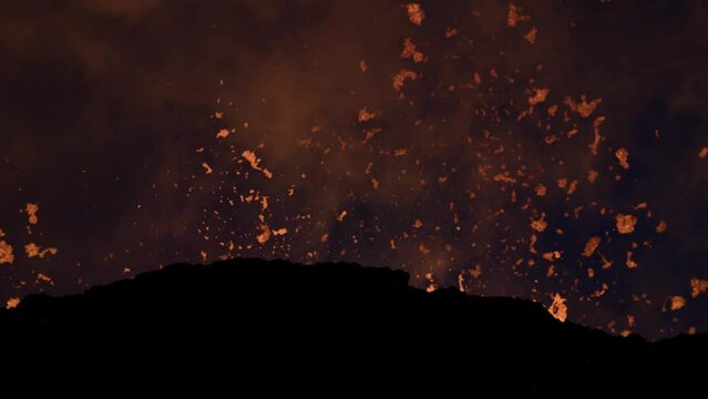 Hot glowing lava shoots high in the air during volatile volcano eruption
