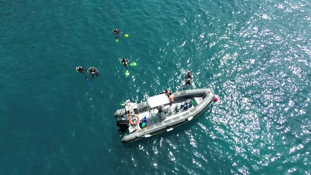 Aerial drone view of a group of divers do scuba diving baptism at yacht taught by instructor