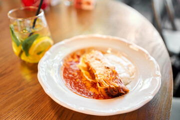 Lasagna bolognese close up. Served traditional Italian cuisine. DIsh with pasta, meat, tomato sauce, grated cheese and basil leaves in plate. Italy culinary. Restaurant food portion, main course