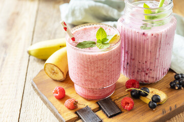 Raspberries, bananas and black currant. Set of fresh various delicious milkshakes or smoothies with fresh berries. Copy space.