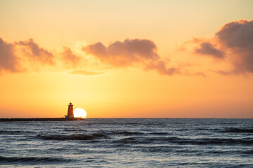 Sunrise with tranquil yellow sky and lighthouse