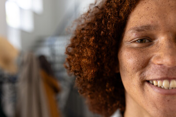 Portrait of happy caucasian man with curly hair over stairs at home