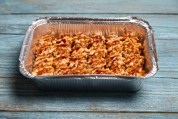 Baked hot sushi rolls in a baking dish on a blue wooden background