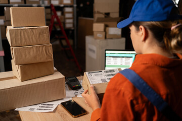 Storehouse worker. Young woman putting labels on products while working in the storehouse