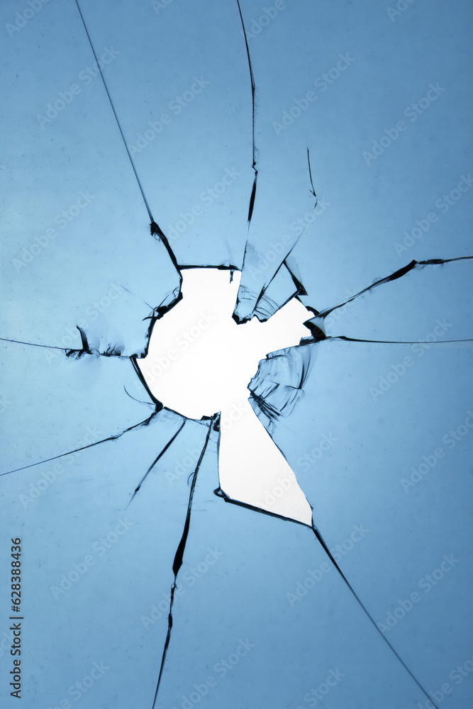 Poster glass texture of a broken window with a hole and cracks on a blue background.