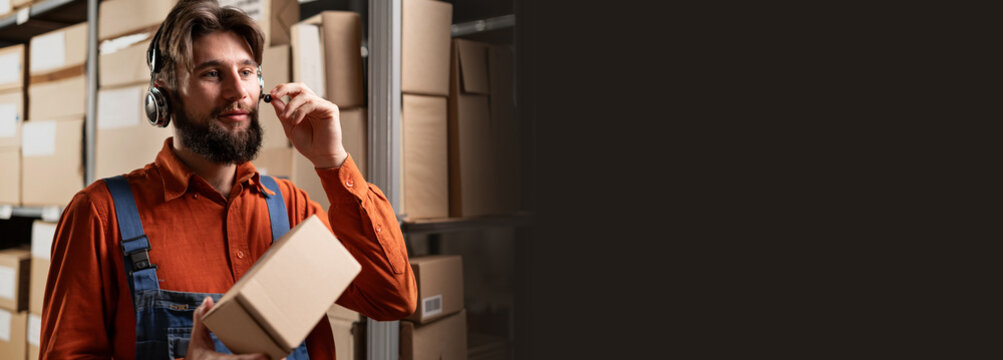 Warehouse worker using headset holding package for delivery to customer. Banner.