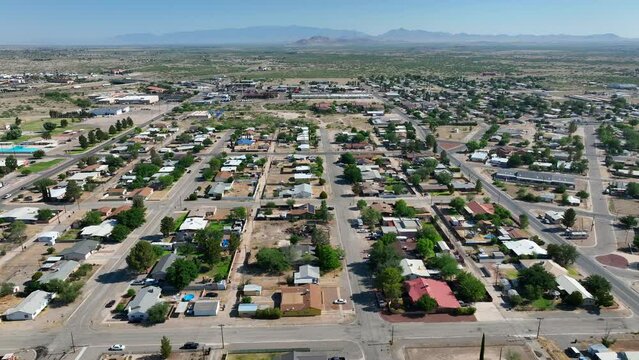 Houses and homes in southwest USA neighborhood. Aerial truck shot of housing development in desert with mountains in distance.