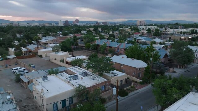 Old town Albuquerque, New Mexico housing. Aerial rising shot from adobe houses and homes reveals skyline at dusk.